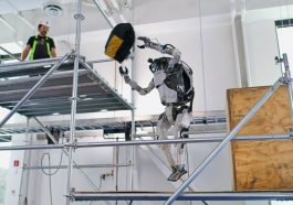 Le robot humanoide Atlas en train de lancer un sac d’outils a un ouvrier sur un echaffaudage
