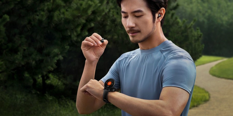 Un homme en train de mettre des ecouteurs sans fil et regarder sur sa montre connectee 