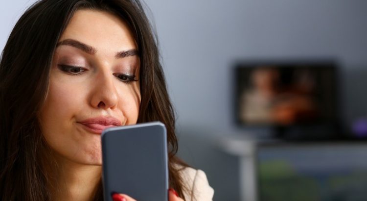 Une femme en train de regarder dans son smartphone