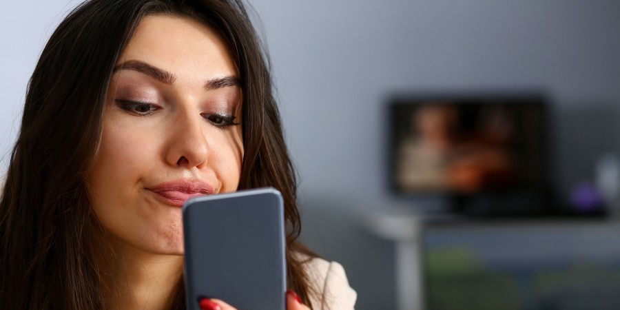 Une femme en train de regarder dans son smartphone 