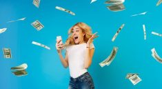 Une femme criant de joie en regardant son telephone avec des billets d’argent qui tombent autour d’elle