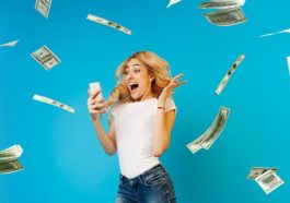 Une femme criant de joie en regardant son telephone avec des billets d’argent qui tombent autour d’elle