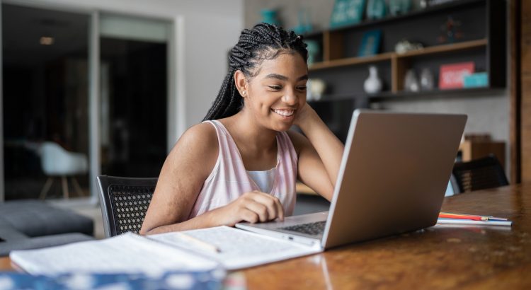 Une jeune étudiante souriant devant son ordinateur