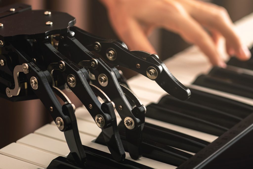 Une main de robot et une main humaine jouant du piano 