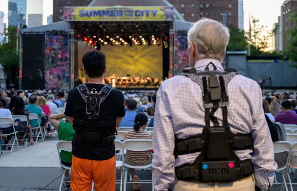 Photos de dos de deux personnes portant les vestes tactiles pour sourd Music: Not Impossible 