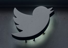 Logo Twitter gris sur fond noir