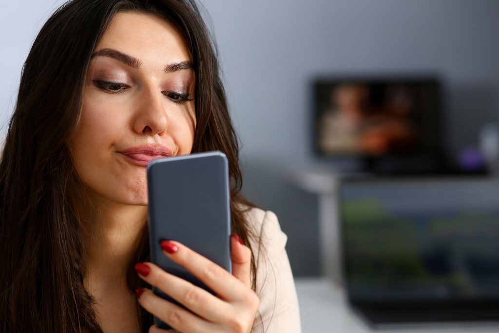 Une jeune femme brune regardant dans son smartphone